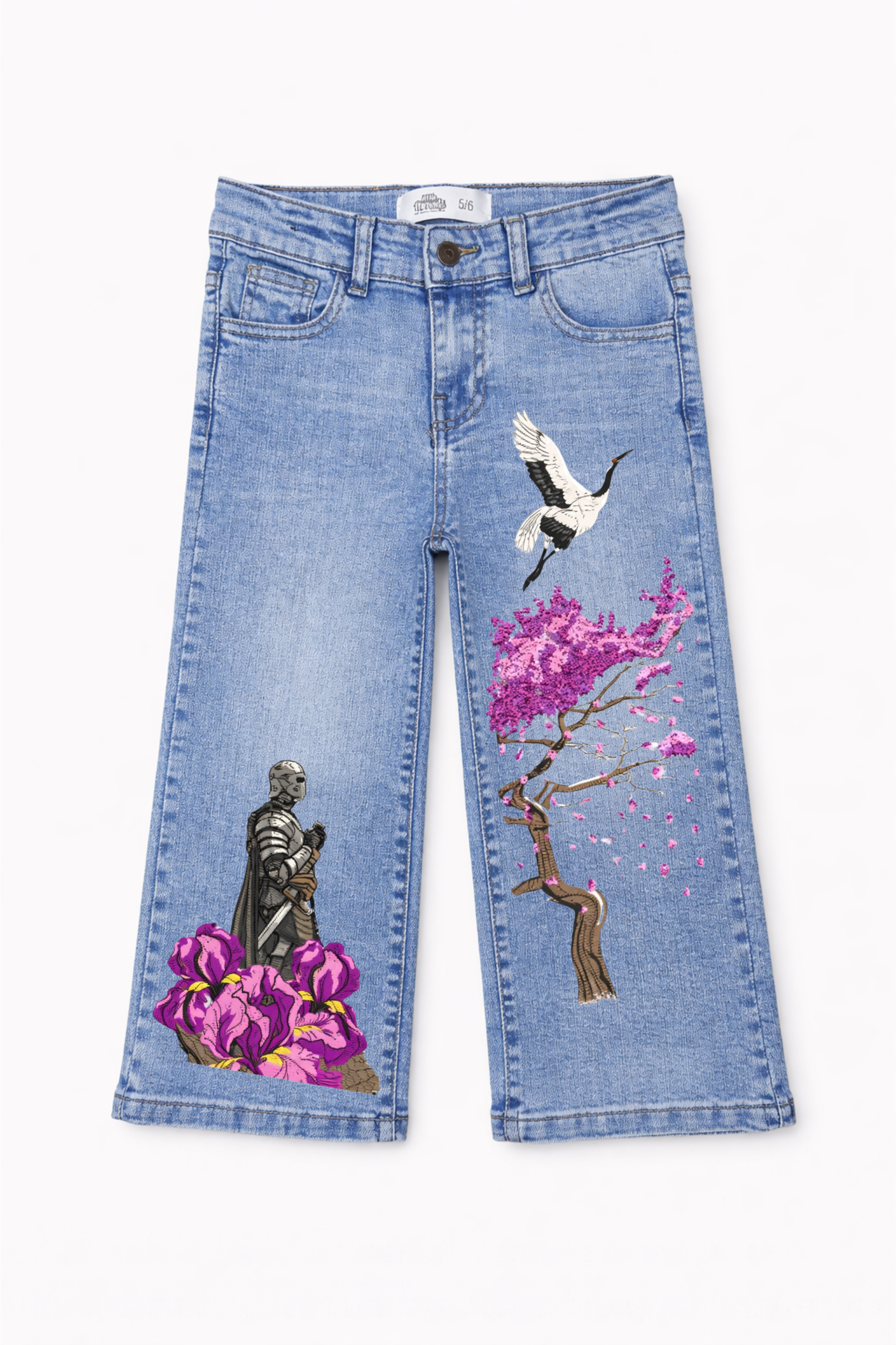 Blue jeans with artistic designs of a bird, tree, and statue on a white background