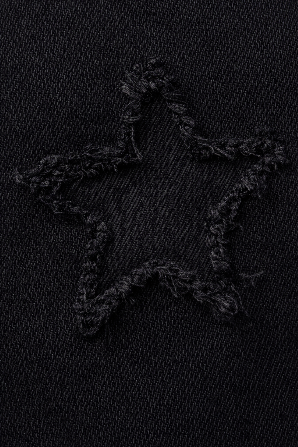 Black star-shaped object on a textured black surface